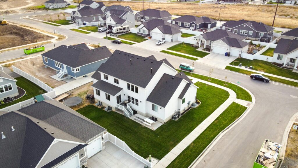 Scenic aerial view of a residential area in Spanish Fork, Utah featuring modern houses and green lawns.